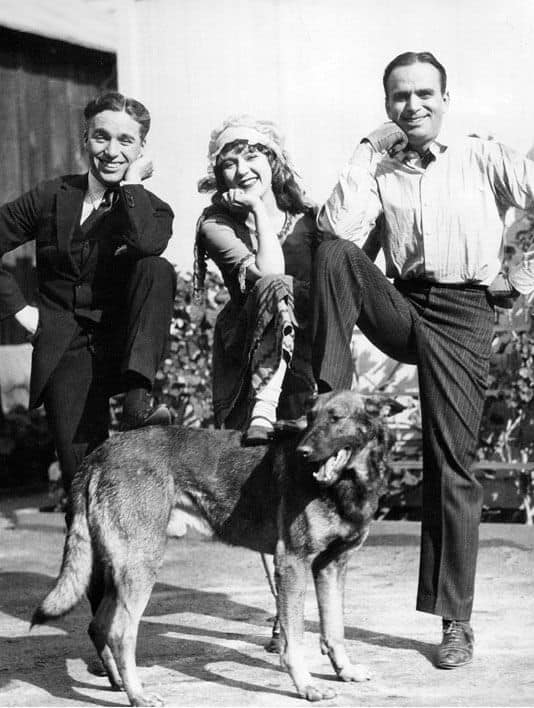 A group of people posing with a dog.