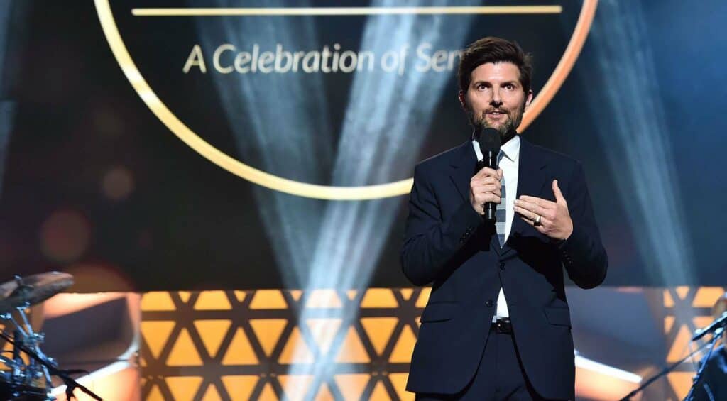 A man in a suit speaking into a microphone.