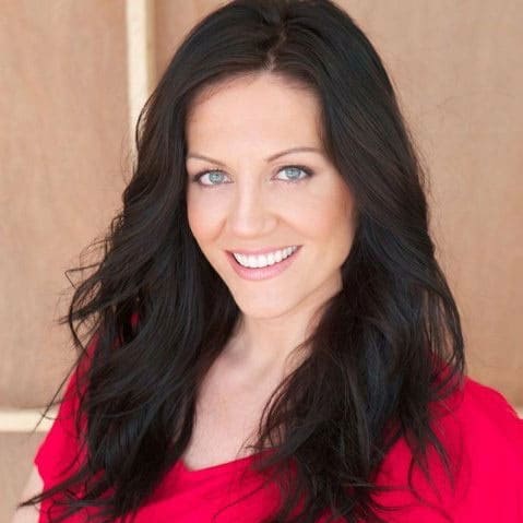 A woman with long black hair smiling in a red shirt.