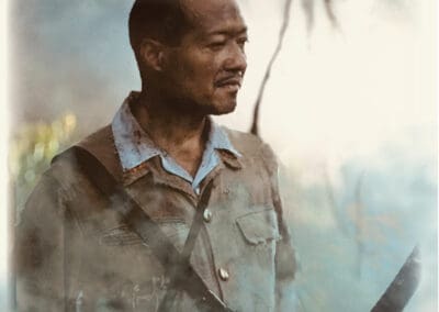 A man holding a gun in front of smoke.