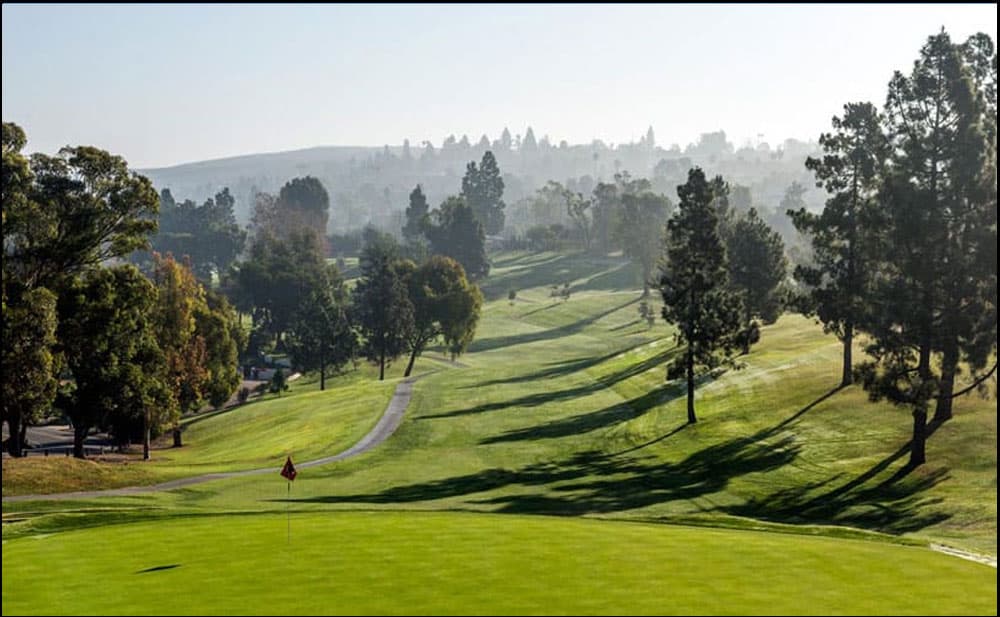 A green golf course in a mountainous area.