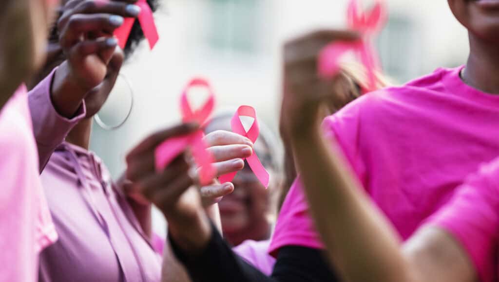 Breast Cancer Awareness Ribbons In Women's Hands